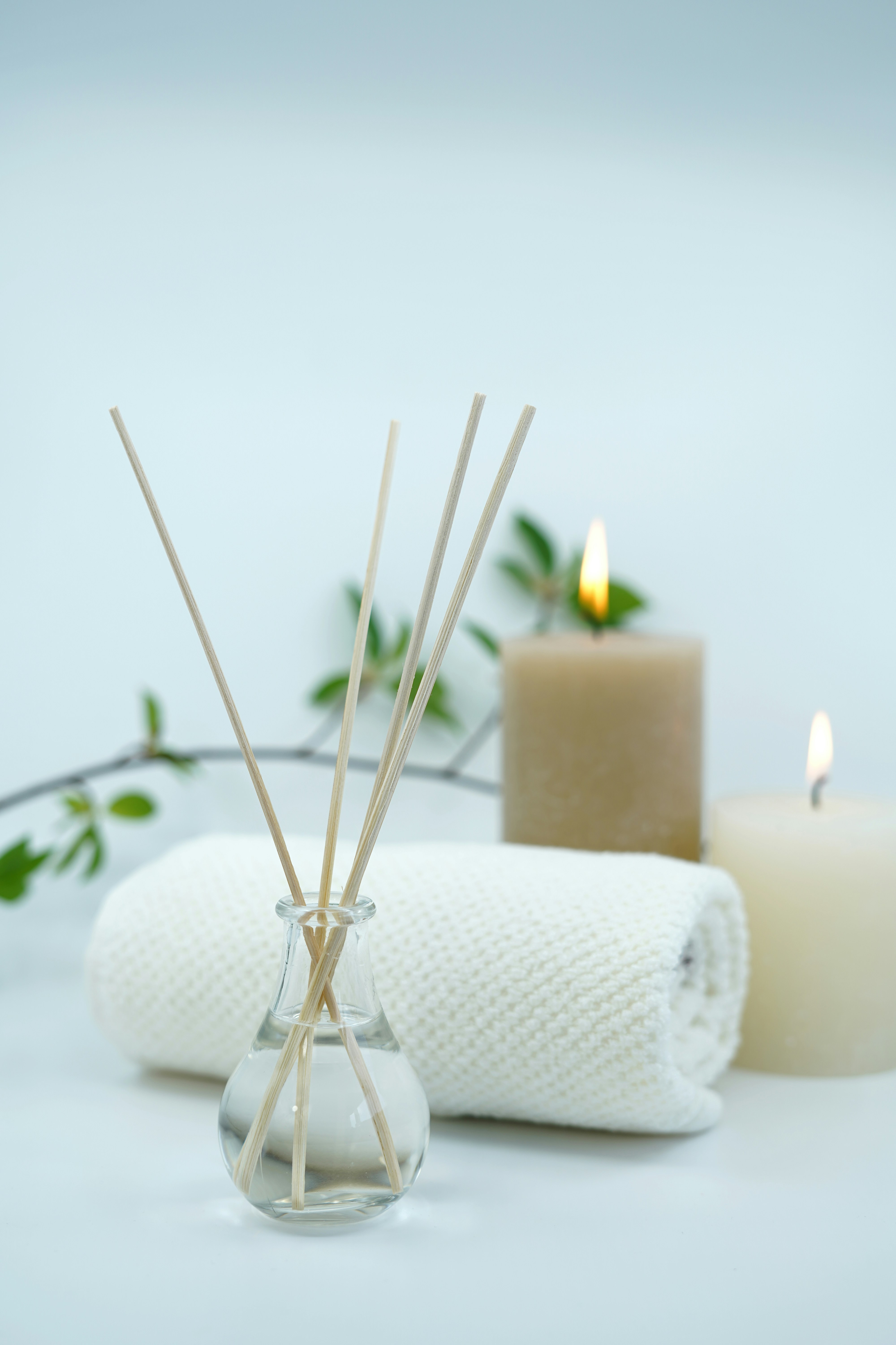 Aromatherapy diffuser and candles beside a folded towel.