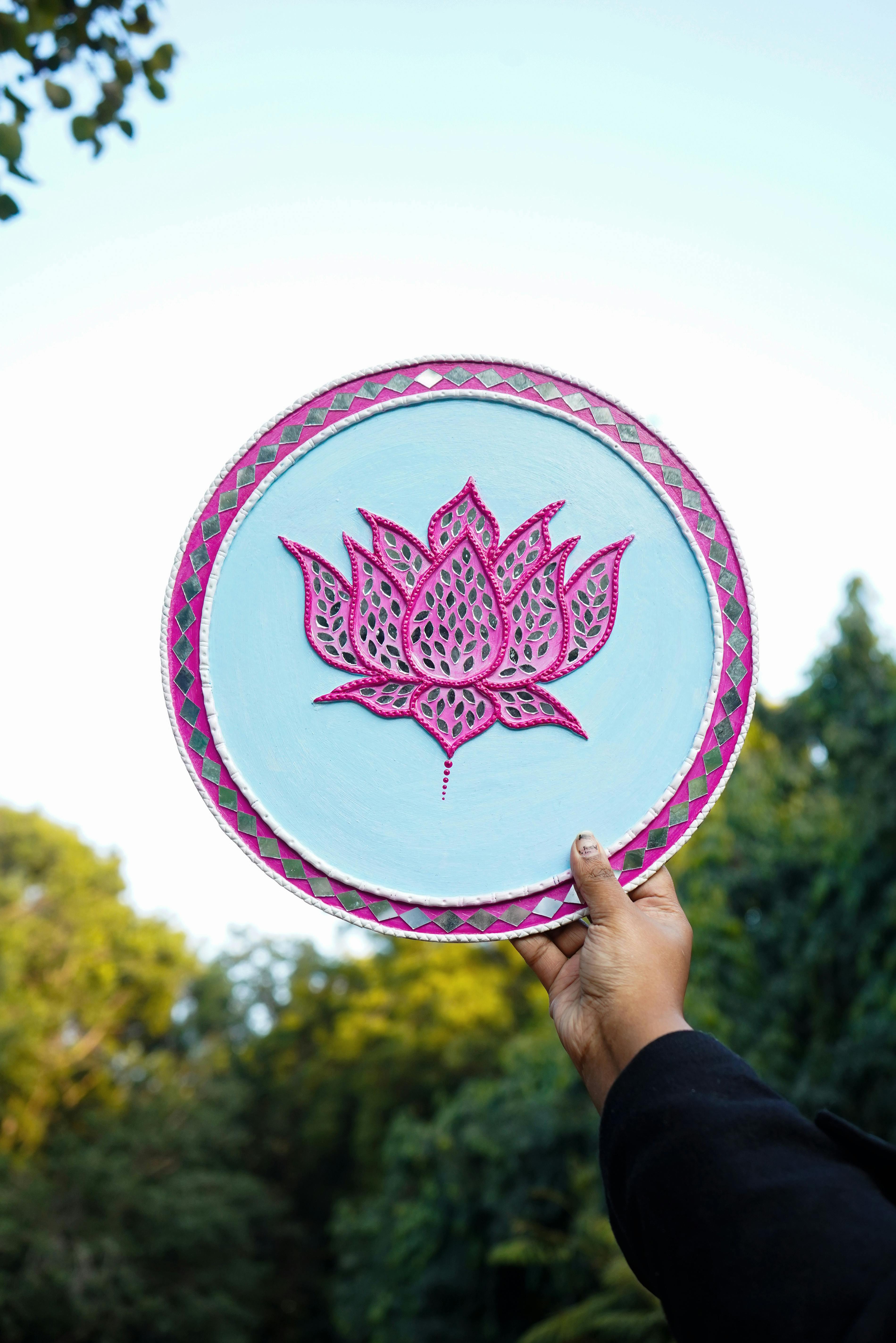 Painted lotus plaque held to the sky.