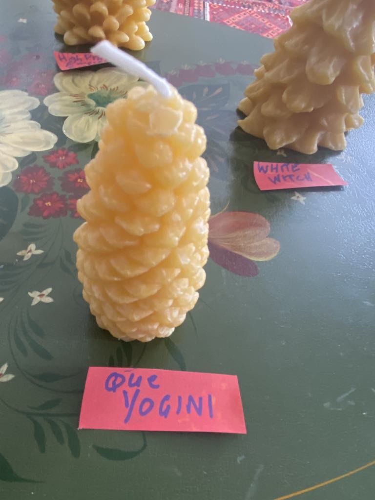 Tall beeswax candle labeled Yogini.