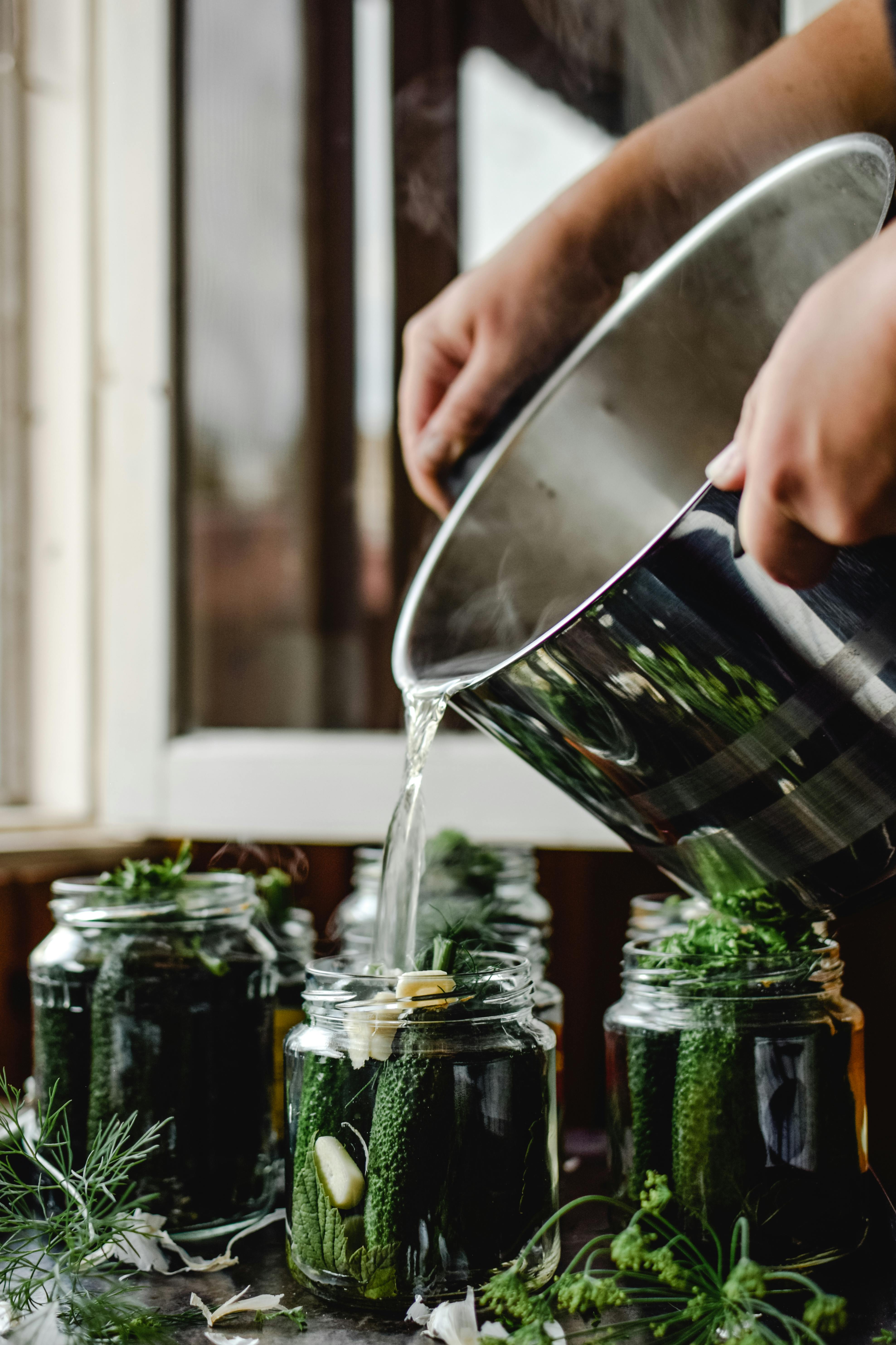 Hot brine poured over herbs and cucumbers.